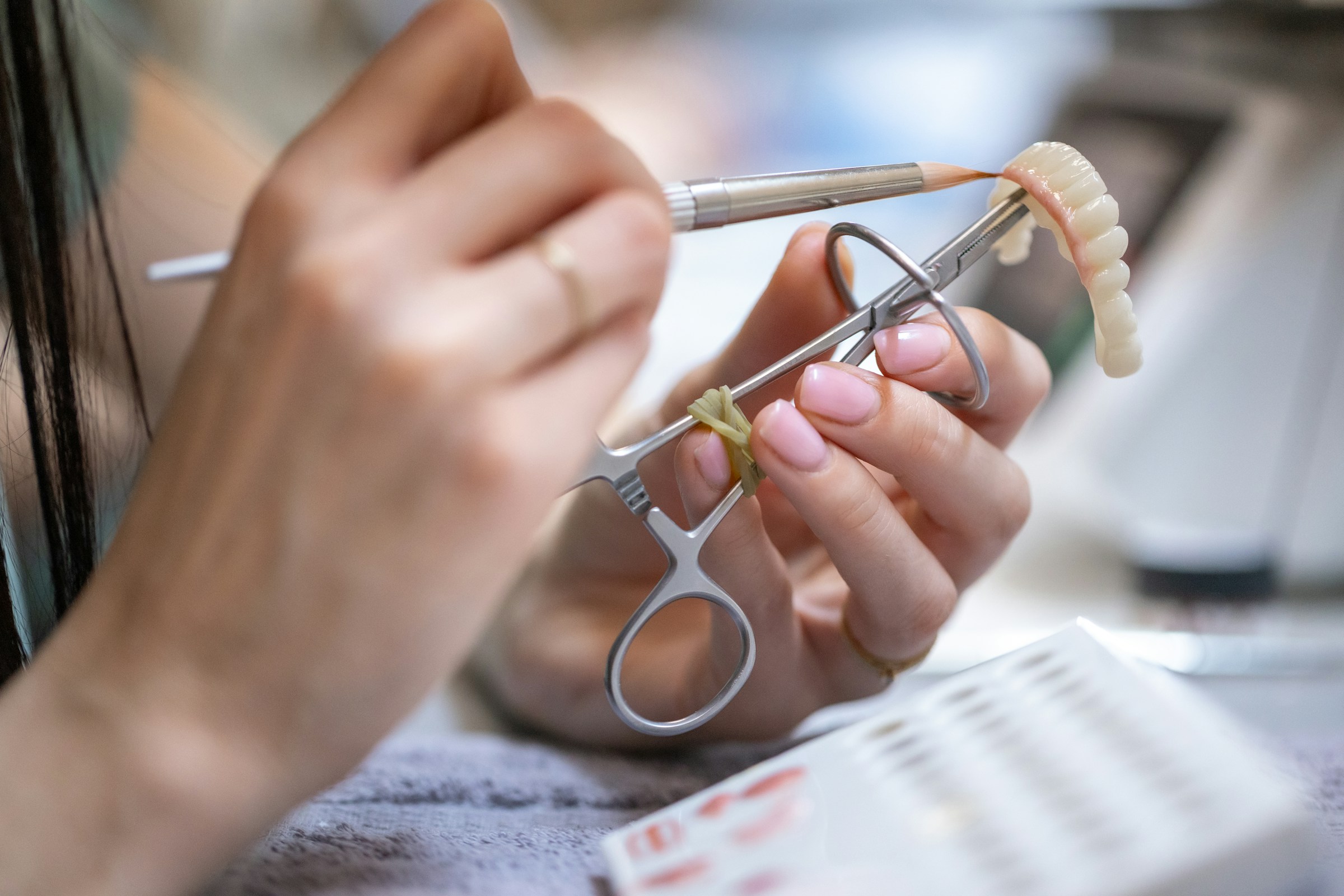 Zorgvuldig handwerk aan een gebitsprothese, illustratieve foto